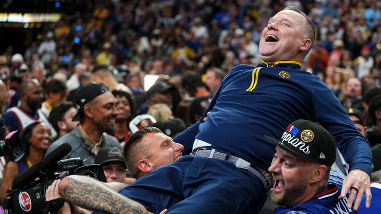 Denver Nuggets head coach Michael Malone is hoisted up by Nikola Jokic and his brother
