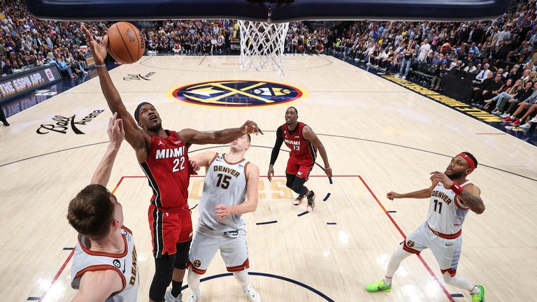 Miami Heat forward Jimmy Butler and Denver Nuggets guard Christian Braun compete for possession 